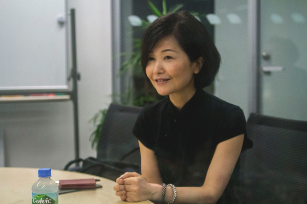 Japanese-woman-interviewed1 phone recording a conference room