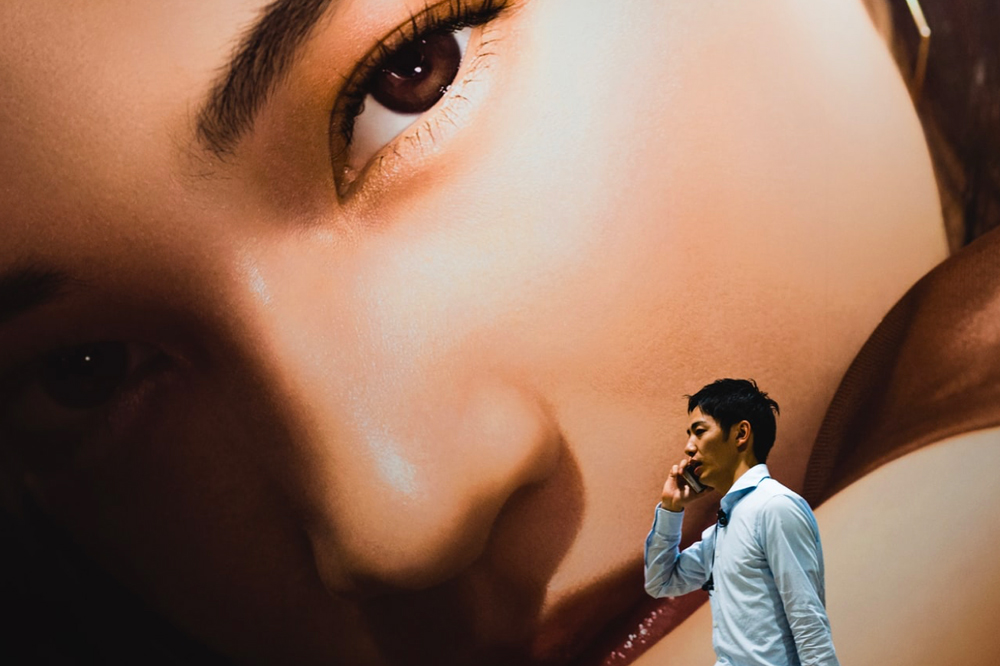 Japanese_man_walking_past_advertising Man walking past large murial